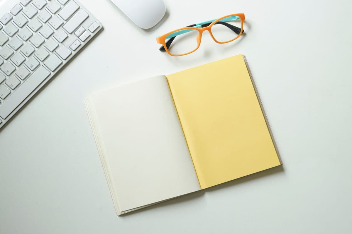 An open notebook and pen on a writing desk