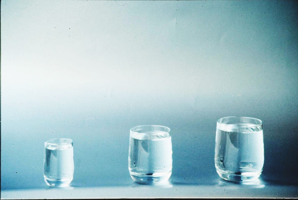 Two glasses of water side by side, one clear and one clouded